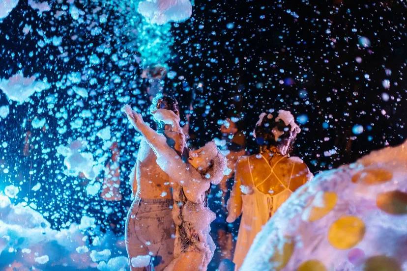 A foam party after dark, lit like a music video — photo 2