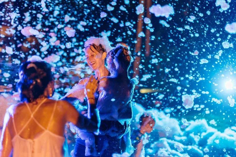 A foam party after dark, lit like a music video — photo 4