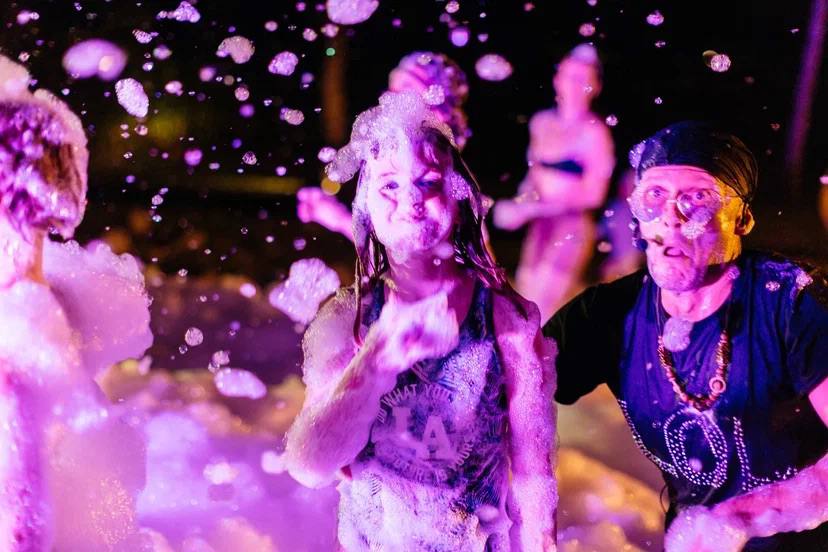 A foam party after dark, lit like a music video — photo 7